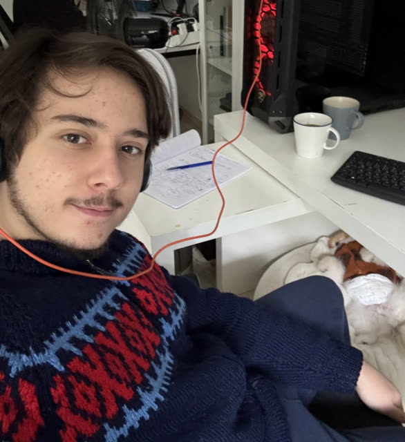 Göktürk, köpeği yanındayken masasında Stylingmate üzerinde çalışıyor.